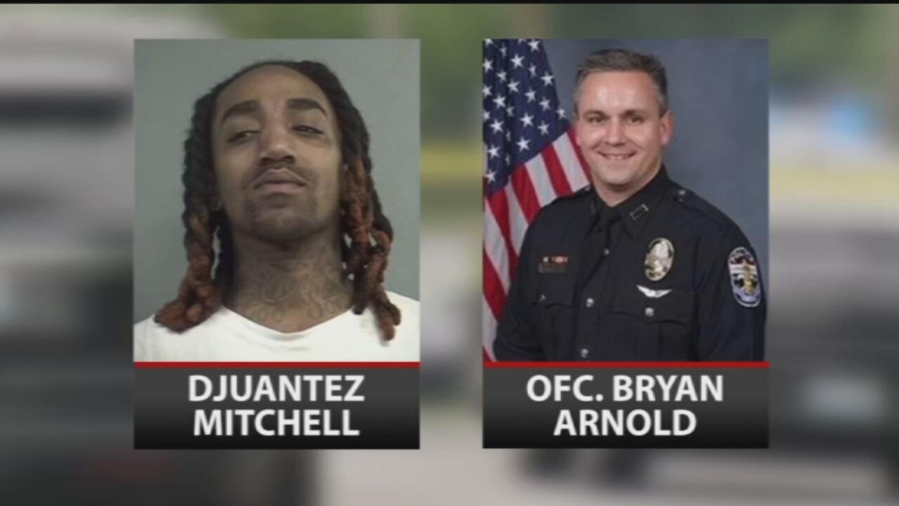 D’Juantez Mitchell, left, and Louisville Metro Police Officer Bryan Arnold